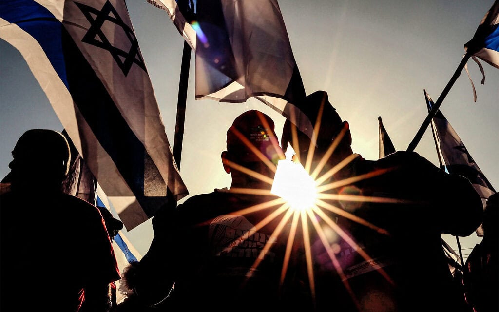יוצאי צבא מניפים את דגלי ישראל במהלך הפגנה נגד חקיקת המהפכה המשפטית של הממשלה, לצד כביש מהיר סמוך לנתניה. 28 במרץ 2023 (צילום: JACK GUEZ / AFP) יוצאי צבא מניפים את דגלי ישראל במהלך הפגנה נגד חקיקת המהפכה המשפטית של הממשלה, לצד כביש מהיר סמוך לנתניה. 28 במרץ 2023 (צילום: JACK GUEZ / AFP)