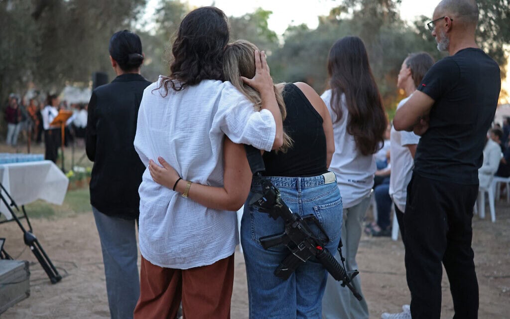 ישראלים מתחבקים במהלך טקס זיכרון בקיבוץ כפר עזה שבדרום הארץ. 7 באוקטובר 2026 (צילום: Ilia YEFIMOVICH / AFP) ישראלים מתחבקים במהלך טקס זיכרון בקיבוץ כפר עזה שבדרום הארץ. 7 באוקטובר 2026 (צילום: Ilia YEFIMOVICH / AFP)