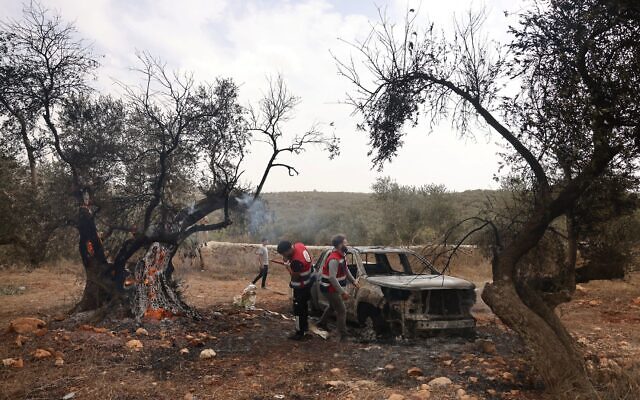 מתנדבים פלסטינים מכבים עץ זית שהוצת, לצד רכב בבעלות פלסטינית, לפי דיווחים בידי מתנחלים, סמוך לכפר תורמוס עיא שמצפון לרמאללה, בגדה המערבית. 16 באוקטובר 2026 (צילום: AHMAD GHARABLI / AFP) מתנדבים פלסטינים מכבים עץ זית שהוצת, לצד רכב בבעלות פלסטינית, לפי דיווחים בידי מתנחלים, סמוך לכפר תורמוס עיא שמצפון לרמאללה, בגדה המערבית. 16 באוקטובר 2026 (צילום: AHMAD GHARABLI / AFP)
