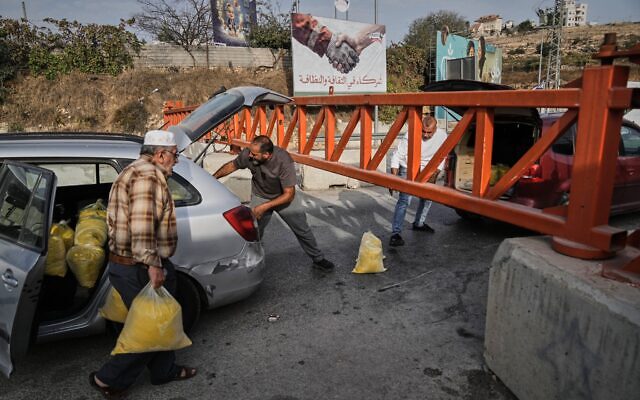 פלסטינים מעבירים שקי סולת דרך שער צבאי הסגור לכלי רכב במהלך מבצע של צה"ל בחברון שבגדה המערבית, 24 באוקטובר 2026, יום לאחר פיגוע ירי פלסטיני באזור (צילום: AP Photo/Mahmoud Illean) פלסטינים מעבירים שקי סולת דרך שער צבאי הסגור לכלי רכב במהלך מבצע של צה"ל בחברון שבגדה המערבית, 24 באוקטובר 2026, יום לאחר פיגוע ירי פלסטיני באזור (צילום: AP Photo/Mahmoud Illean)