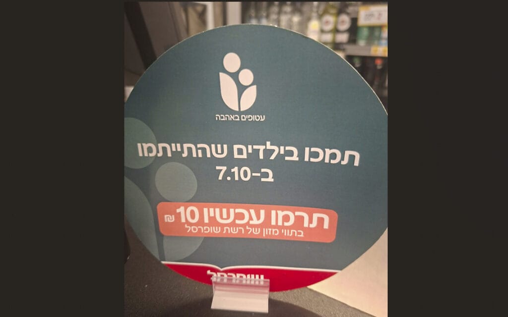 שלט בקשה לתרומה ליתומי השבעה באוקטובר בשופרסל (צילום: טובה הרצל) שלט בקשה לתרומה ליתומי השבעה באוקטובר בשופרסל (צילום: טובה הרצל)